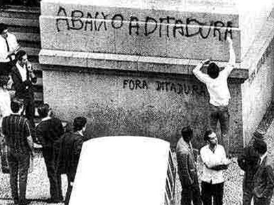 Jovem pichando frases de efeito contra a ditadura durante a Passeata dos 100 mil ocorrida em 26 de junho de 1968. Devido a repercussão dessa passeata, os militares instauraram o AI-5. Jovem pichando frases de efeito contra a ditadura durante a Passeata dos 100 mil ocorrida em 26 de junho de 1968. Devido a repercussão dessa passeata, os militares instauraram o AI-5.